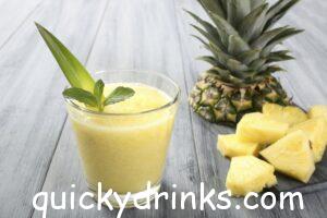 Vibrant Tropical Breeze Smoothie in a tall glass with mint garnish