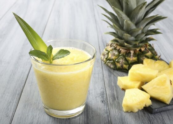 Vibrant Tropical Breeze Smoothie in a tall glass with mint garnish