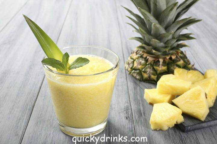 Vibrant Tropical Breeze Smoothie in a tall glass with mint garnish